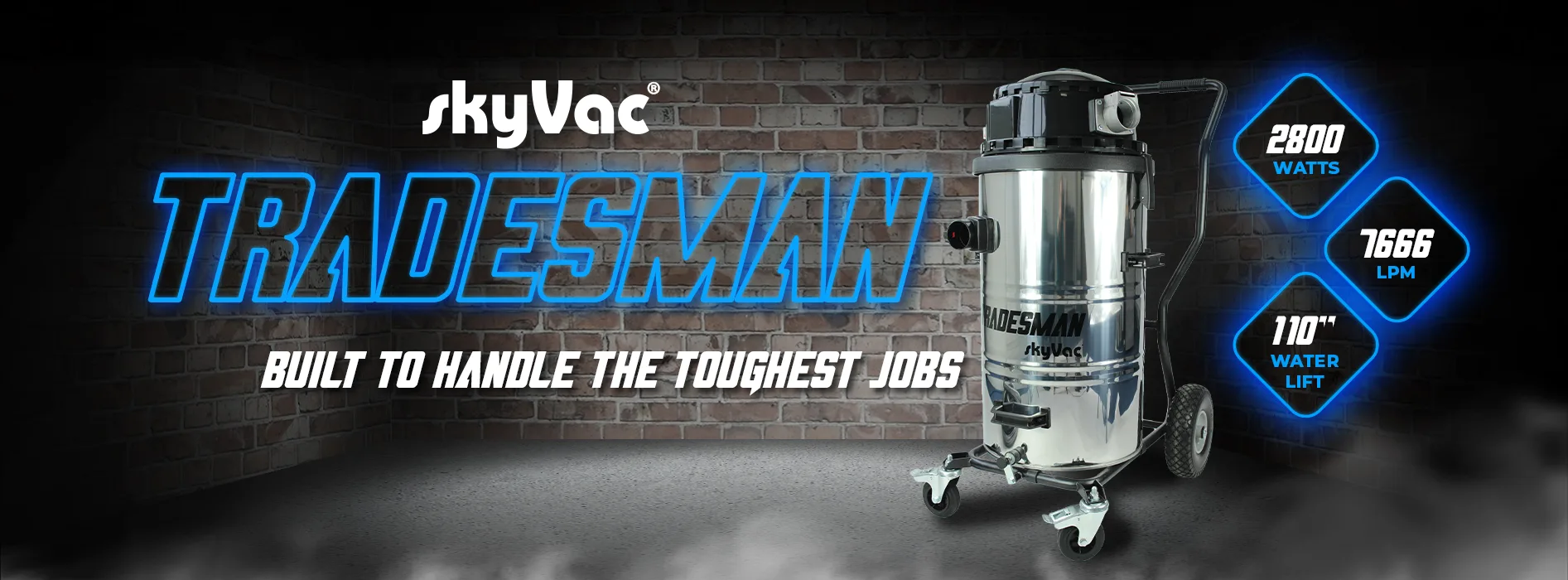Vacuum cleaner standing on wheels against a brick wall, labeled "skyVac TRADESMAN" with specs: 2800 watts, 7666 LPM, 110" water lift, and slogan "BUILT TO HANDLE THE TOUGHEST JOBS."